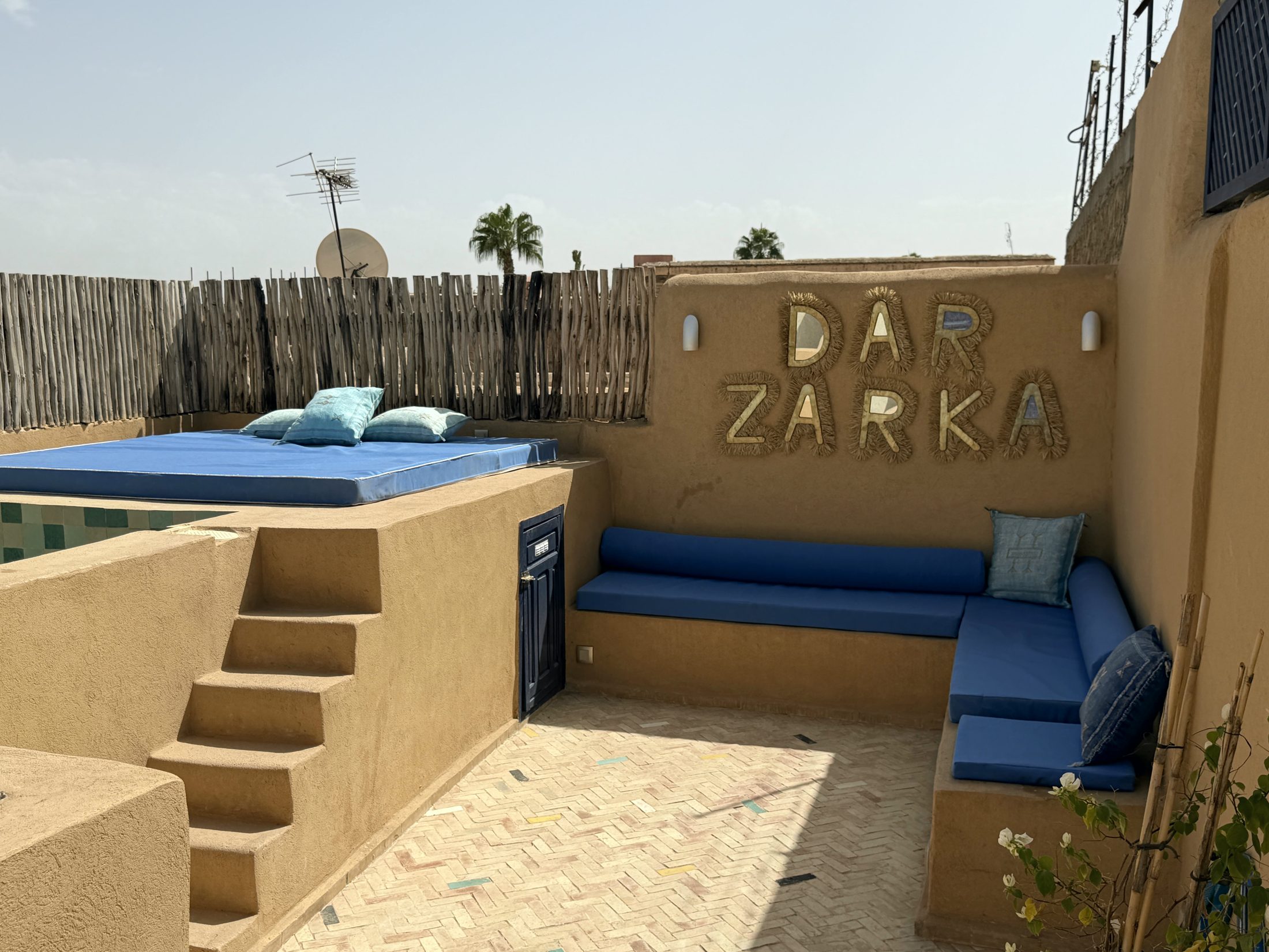 Bassin en zellige turquoise et matelas bleu sur le rooftop de Dar Zarka