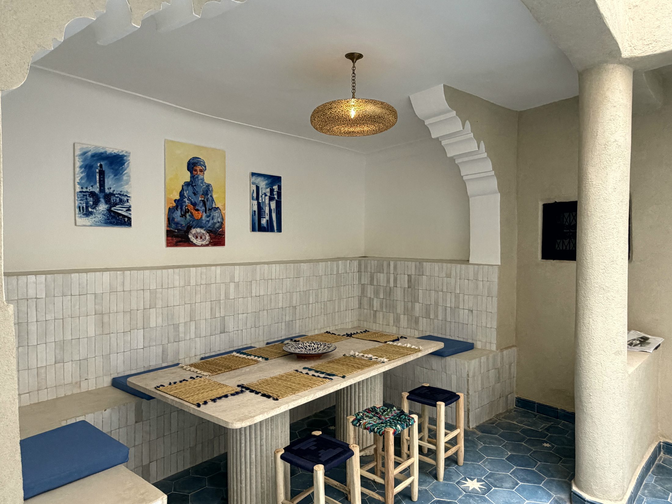 Salon du patio avec banquette bleue et zellige blanc