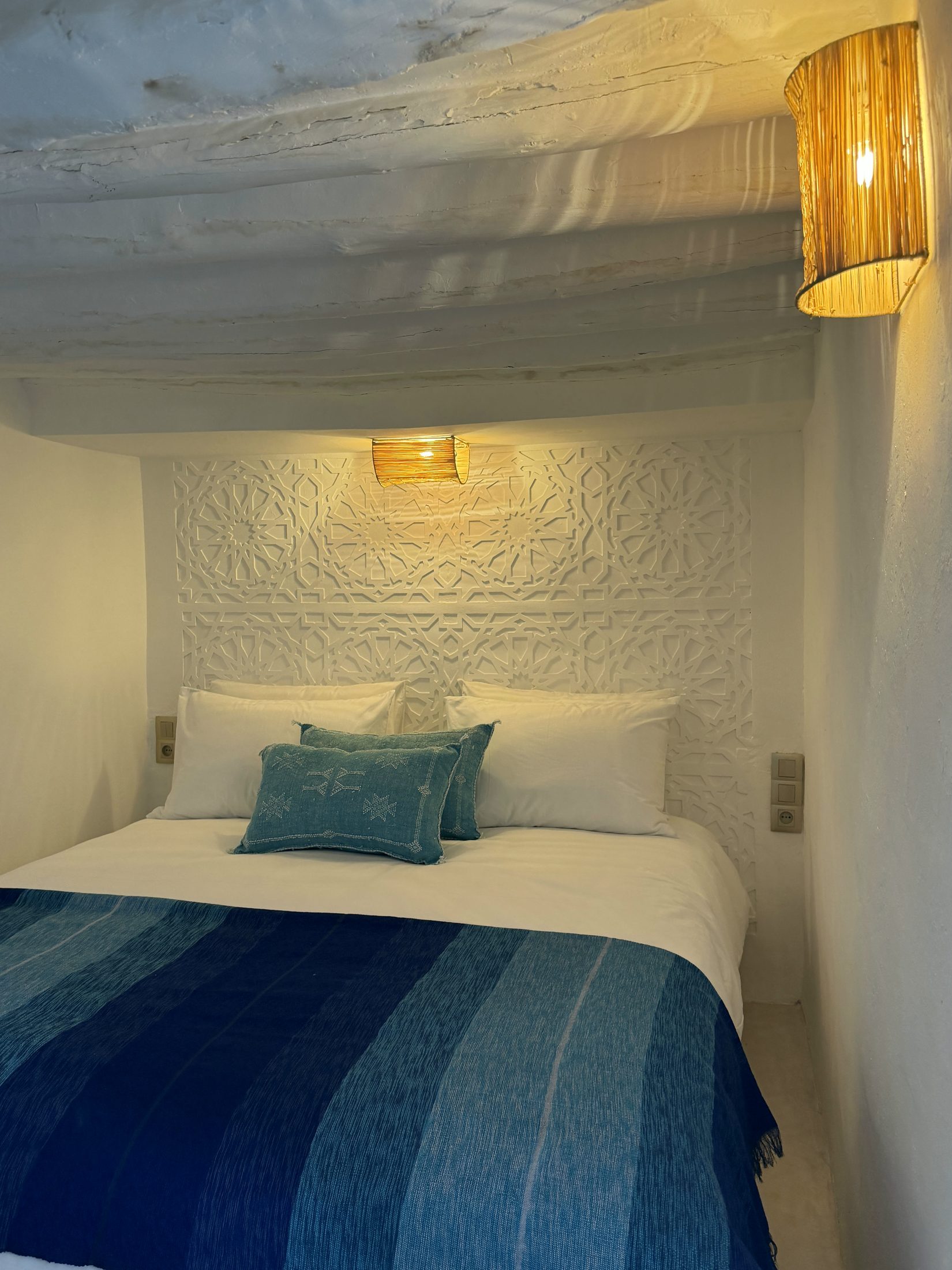 Chambre Les Poutres : plafond aux poutres en bois et tête de lit en plâtre ciselé