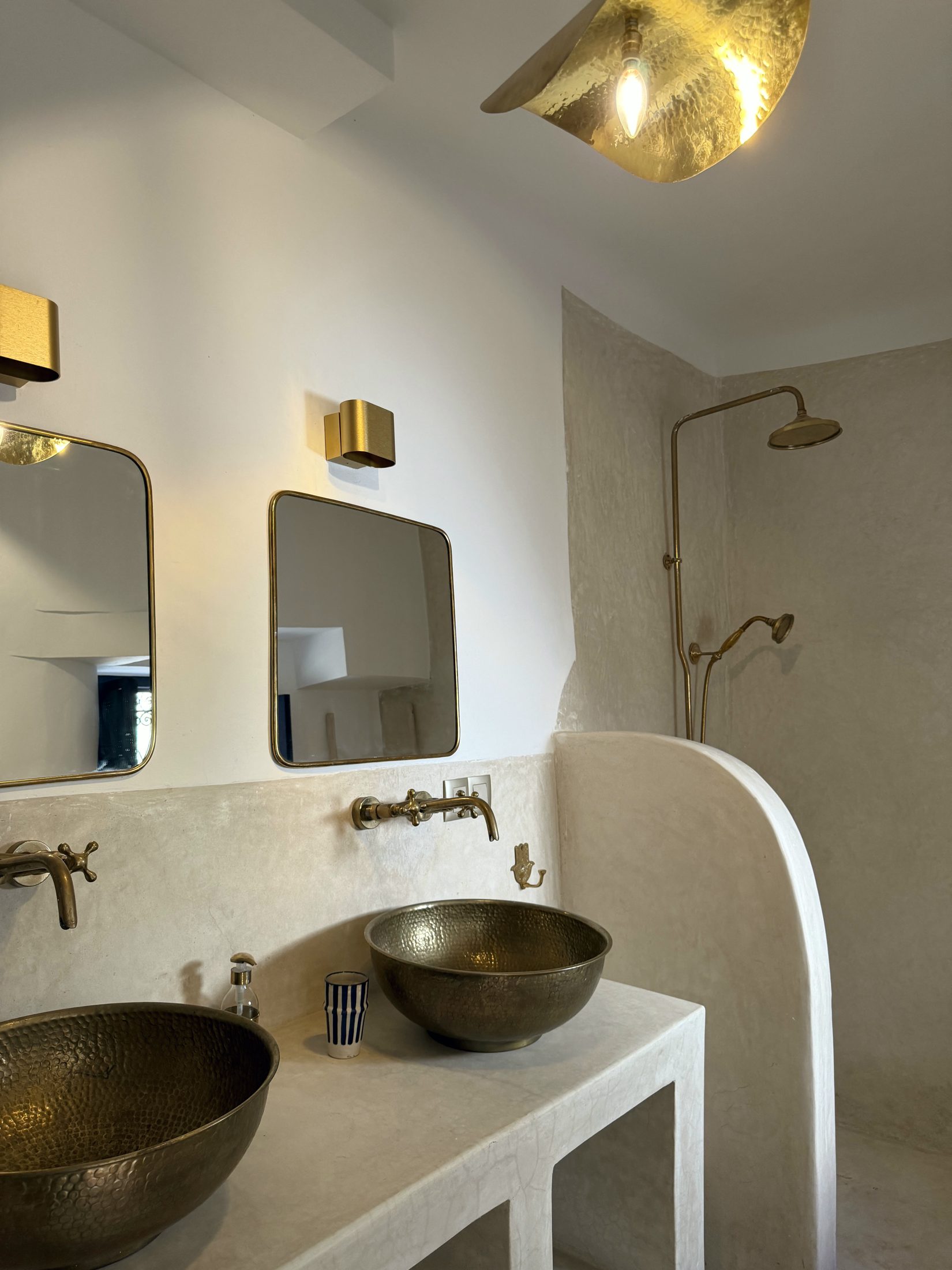 Salle de bain en tadelakt avec deux vasques en laiton martelé