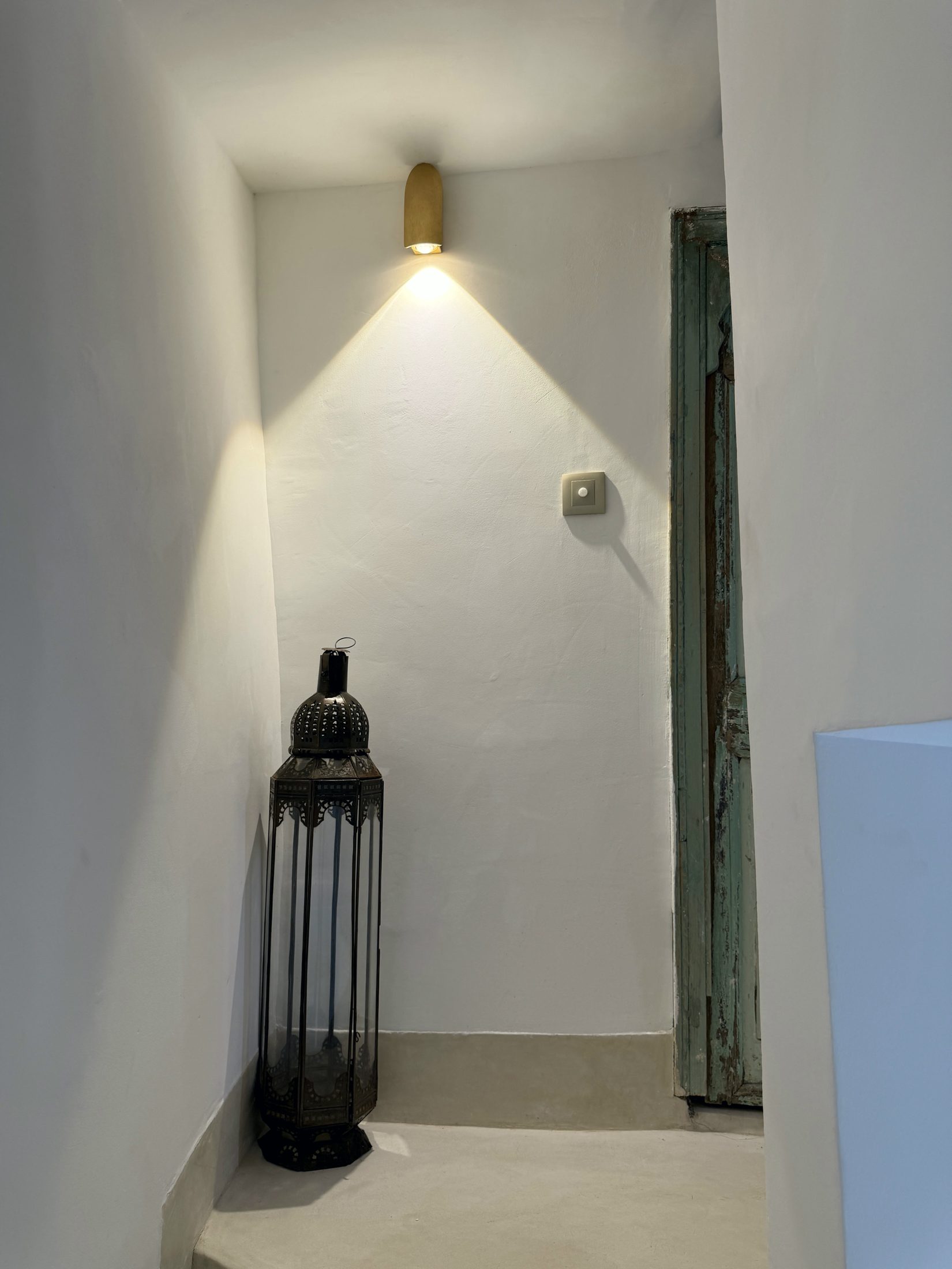 Lanterne posée au pied d'une porte ancienne